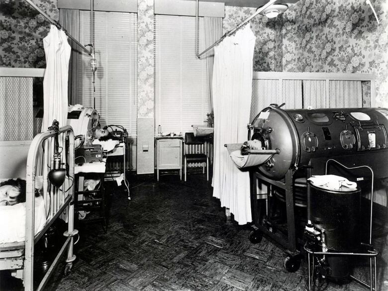 A black and white photograph that depicts a polio ward in the 20th century. 