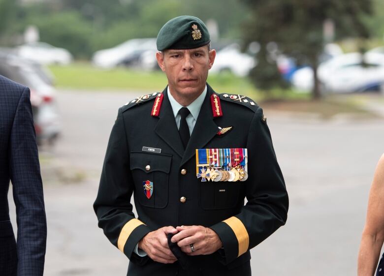 A man in a Canadian Army officer's uniform stands looking at the camera.