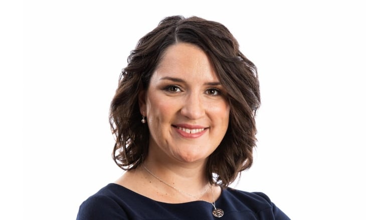 Woman with brown hair smiles to camera.