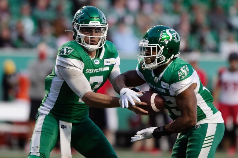 Football player hands off the ball to another player