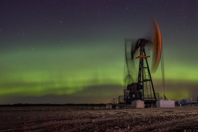 An oil pumpjack operates beneath the aurora borealis just north of Calgary.