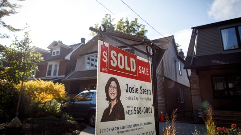 A sold sign in the front yard of a home in Toronto.