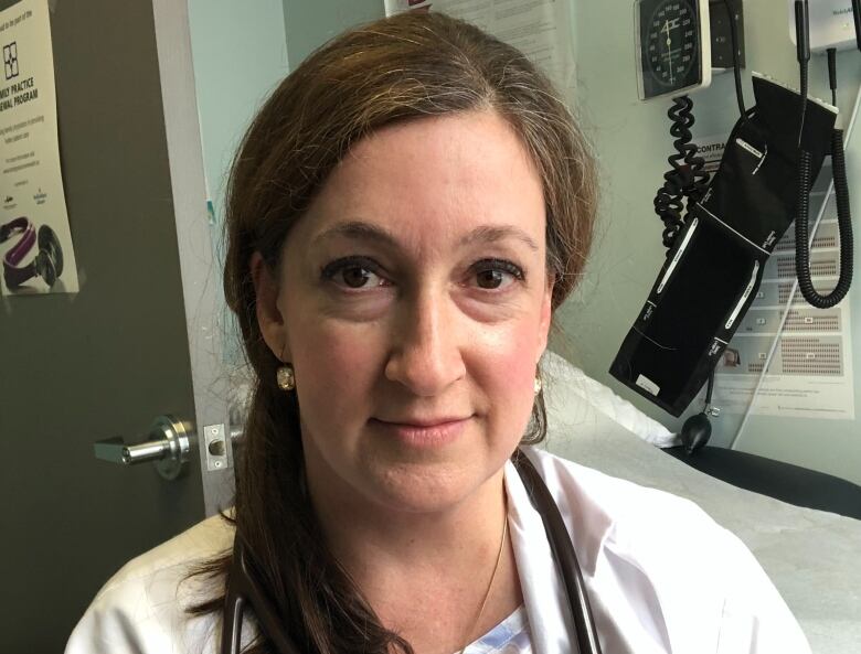 A doctor stands in a evaluation room.