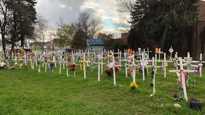 Several rows of white crosses with flowers.