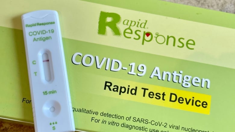 A close-up of a COVID-19 rapid test kit and device, showing a negative result.