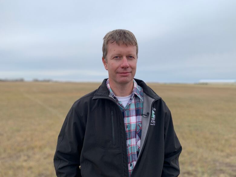 A man standing in a harvested field.