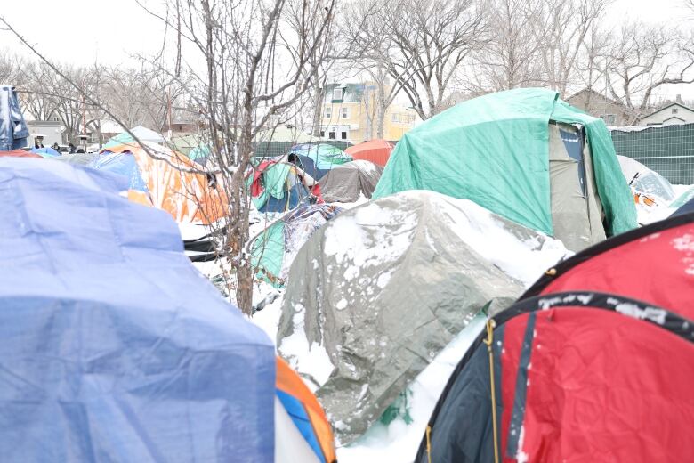 rows of tents outdoors, covered in snow