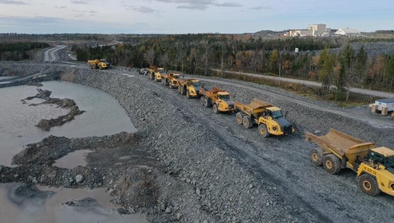 Trucks are lined up on a road at Atlantic Gold's Touquoy mine.