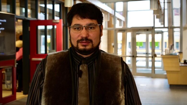 A portrait of a man in a sealskin vest.