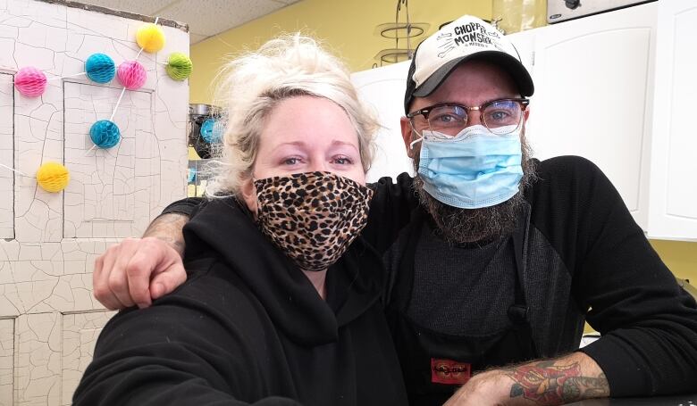 Vanessa Stankiewicz and Miguel Pastor of La Lola Catering inCambridge sit together while wearing masks.