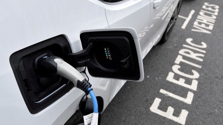 FILE PHOTO: An electric car is charged at a roadside EV charge point, London, October 19, 2021. REUTERS/Toby Melville/File Photo