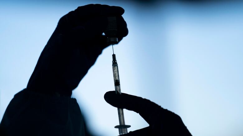 In this file photo, a medical staff member prepares the Pfizer-BioNTech COVID-19 vaccine at Tudor Ranch in Mecca, Calif. on Jan. 21, 2021.