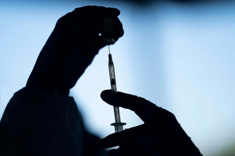 In this file photo, a medical staff member prepares the Pfizer-BioNTech COVID-19 vaccine at Tudor Ranch in Mecca, Calif. on Jan. 21, 2021.