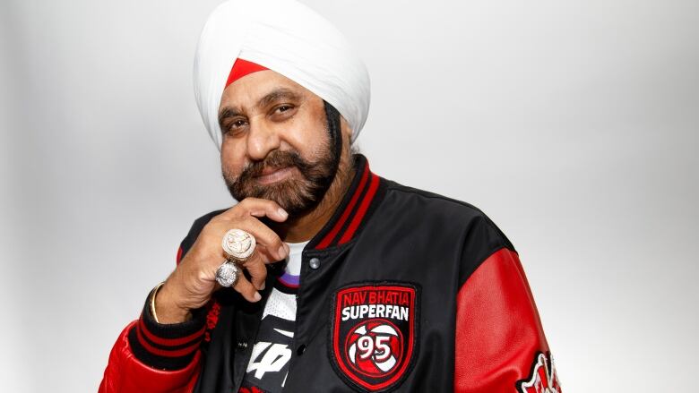 A portrait of a Sikh man with white turban smiling onto the camera.