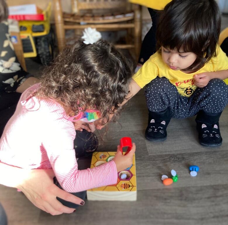 Two toddlers play with toys