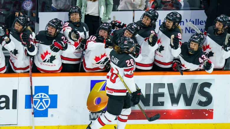 Canada's Emily Clark celebrates scoring a goal with her teammates on the bench.