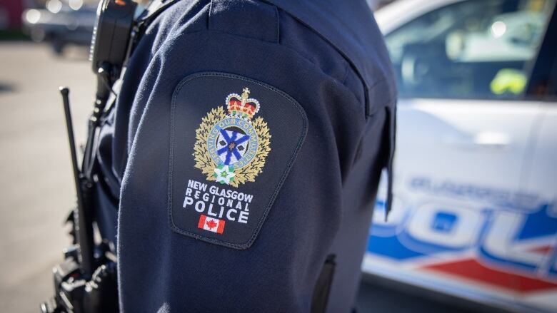 An officer in a uniform with a badge that reads New Glasgow Regional Police.