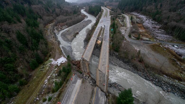 An aerial view of the Coquihalla Highway in B.C. shows the damage caused by flooding in 2021. The four-lane highway is cracked in half on a bridge over the river.