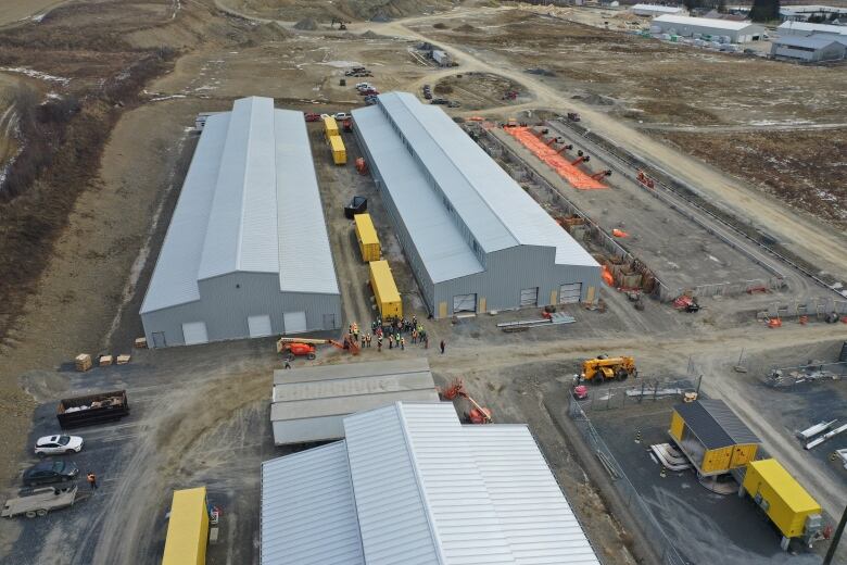 A photo of the tops of three long grey warehouses.