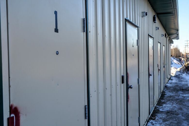 Photo shows building with five separate lockable doors.