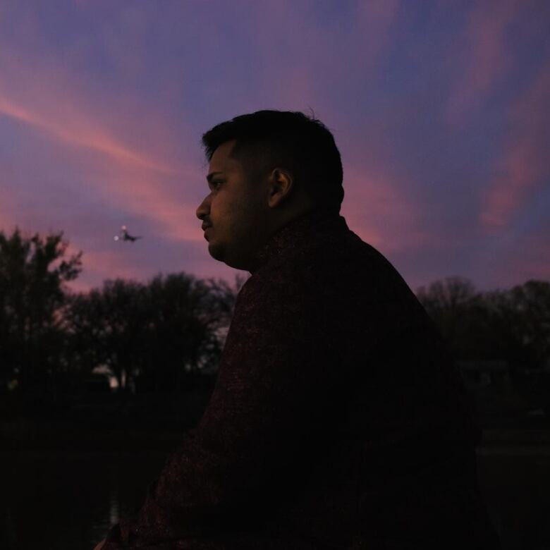 man looking away against a purple sunset