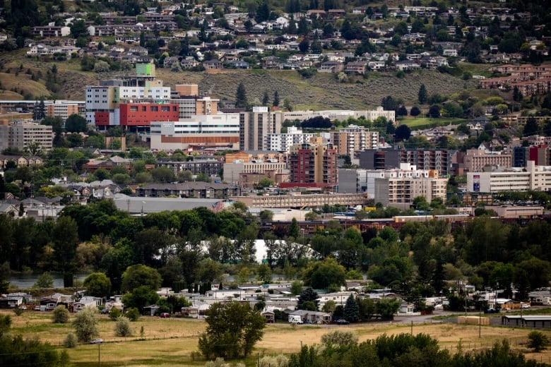 A sprawling array of commercial and residential buildings in a hilly area.