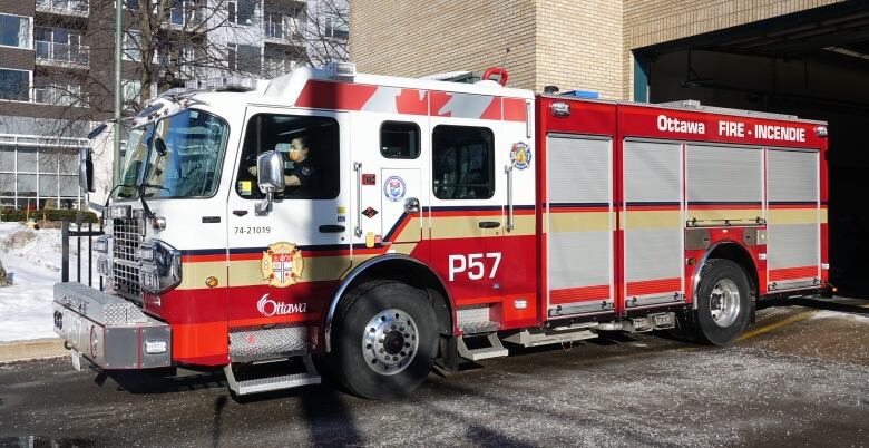 A fire truck on a driveway in winter.