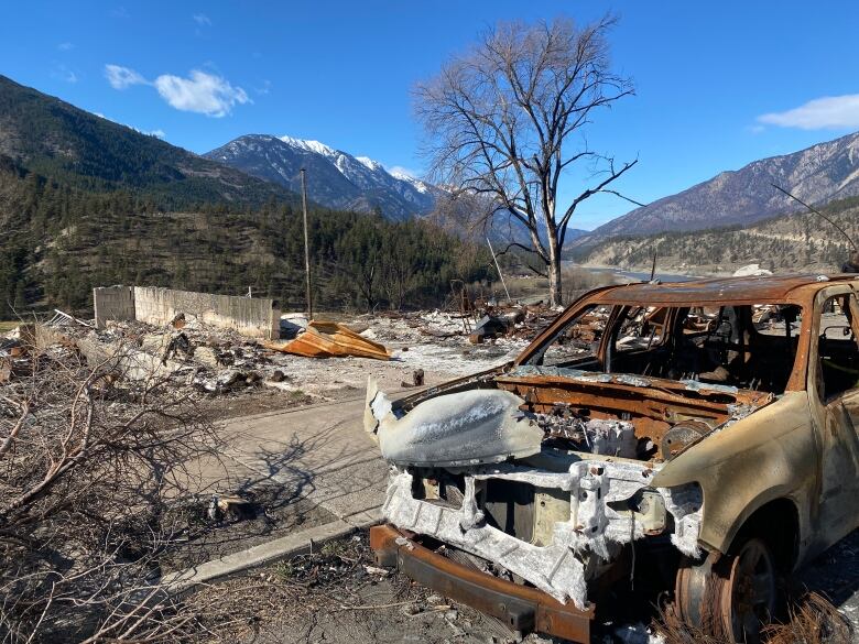 A burned out vehicle and rubble.