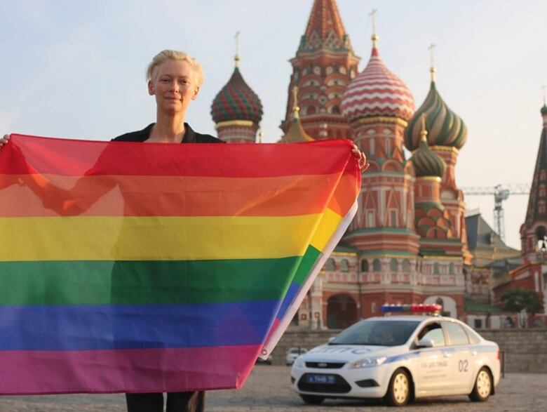 Tilda Swinton with a rainbow flag in front of the Kremlin in Moscow, Russia in 2013.