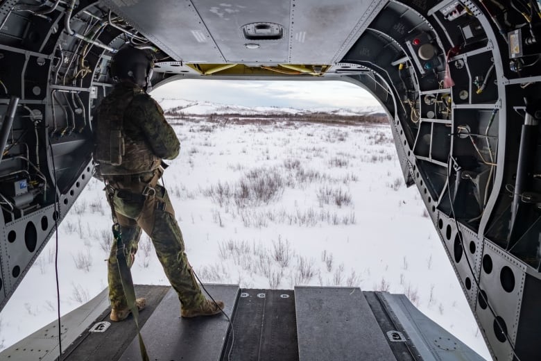 Sergeant Robin Marlow, a CH-147 Chinook Loadmaster with 450 Tactical Helicopter Squadron surveys while on a reconnaissance flight during Joint Pacific Multinational Readiness Capability 22-02 at Fort Wainwright, Alaska on March 4, 2022.