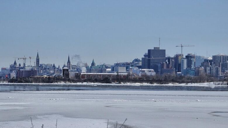 Ottawa's skyline seen from across a partially-thawed river.