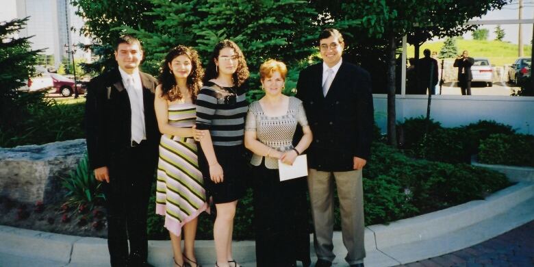 Two men and three women standing together for a picture.