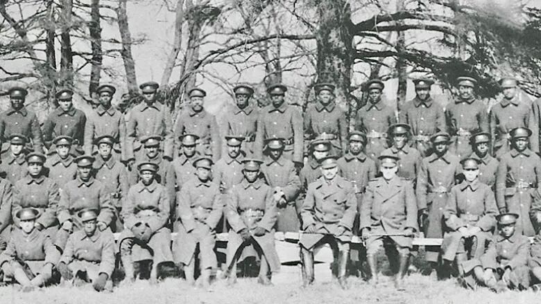 A group of men in military uniforms pose for a photo in 1916.