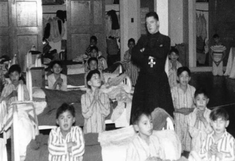 a room of children and a priest