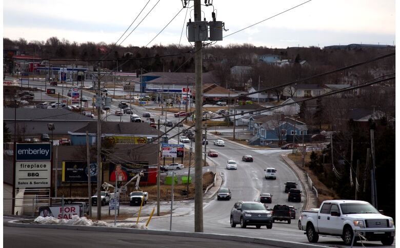 A buy city street with vehicles driving. 