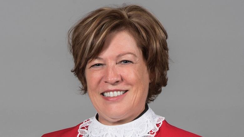 Head shot of a woman in a red judge's gown