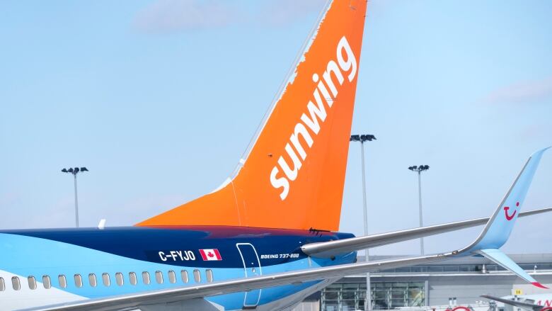 An airplane with an orange tail with the word 