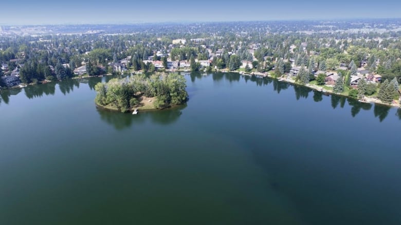 A bird's eye view photo of residential houses along a lake.