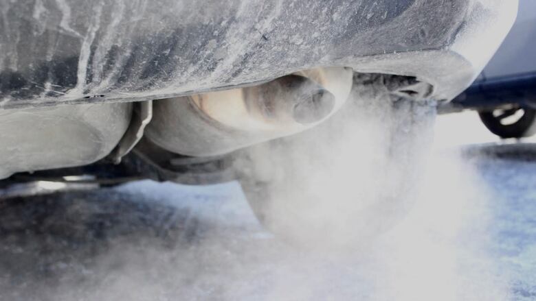 Grey-looking vapour spews out of a pipe from the back of a vehicle.