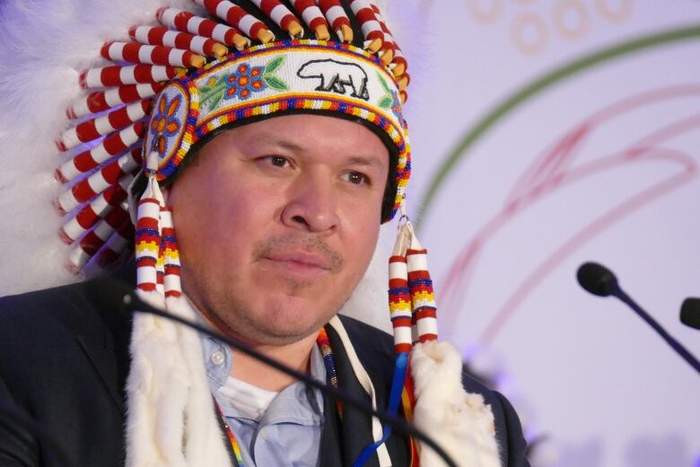 A man wearing a headdress is pictured.