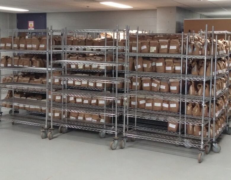 Paper bags with labels on racks in a lab. 