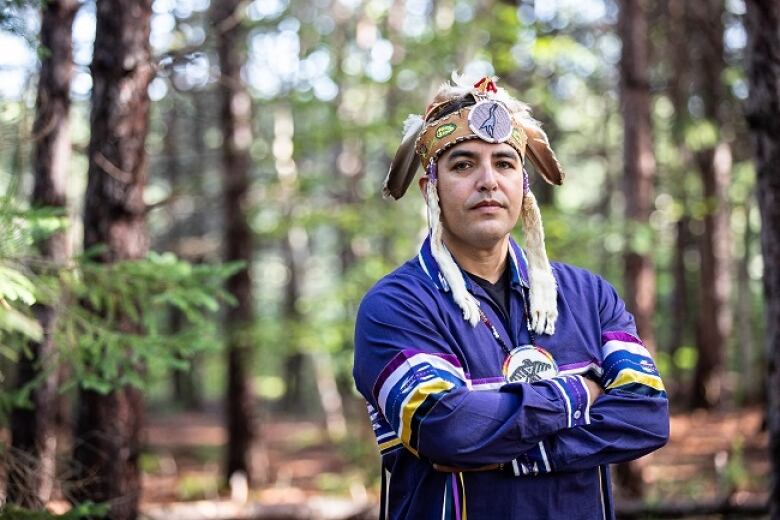 A man wearing an Indigenous headdress. 