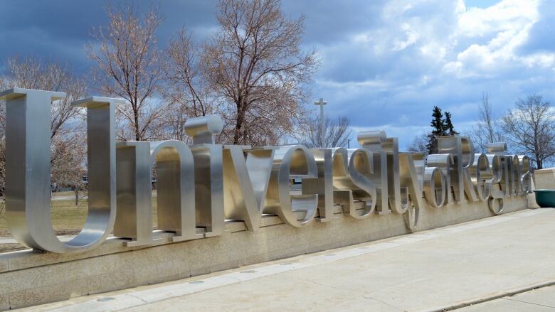 A metal sign indicates the location of the University of Regina