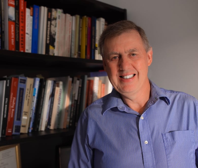 Steve Pomeroy standing in front of a bookshelf.