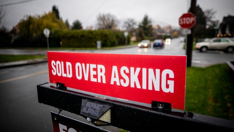 A 'sold over asking' sign on a realtor's advertisement.