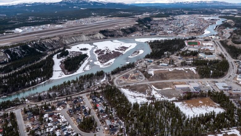 An aerial shot of a small city and a river.