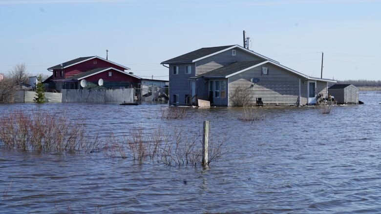 Houses sit in a vast flood of water.