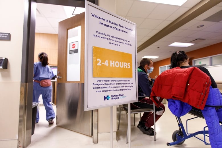 A nurse, and two patience are seen in an emergency room waiting room.