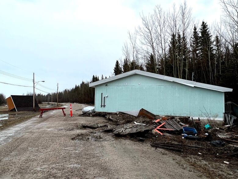 Damaged house sits on a roadway