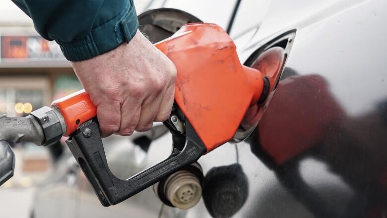 A man pumps gas into a car.